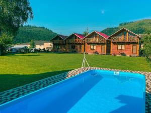 uma casa com piscina em frente a uma casa em Eco Centr Zrub em Maydan