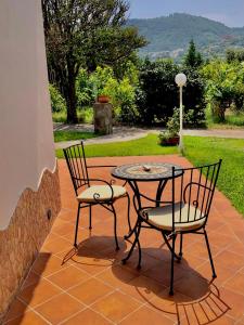 2 Stühle und ein Tisch auf der Terrasse in der Unterkunft Villa Joyosa Apartments in Ischia