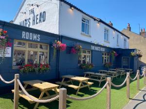 un bâtiment bleu avec des tables de pique-nique devant lui dans l'établissement The Nags Head York, à York