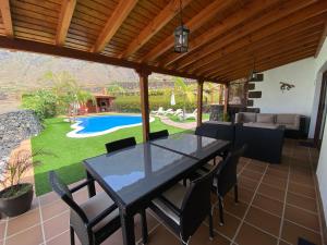 夫隆特拉的住宿－Villamocanes，一个带桌椅的庭院和一个游泳池