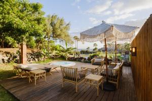 a deck with a table and chairs and an umbrella at 11 Holiday Homes in San Miguel de Abona