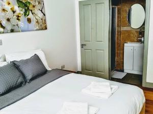 1 dormitorio con cama blanca y baño en Forest House Hotel en Londres
