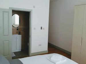 a bedroom with a bed and a bathroom with a mirror at Forest House Hotel in London