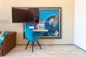 a room with a blue chair and a picture on the wall at CMA Stift Ossiach in Ossiach