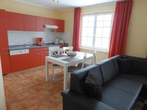 un soggiorno con divano e tavolo e una cucina di Villa Isabell a Binz