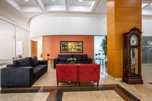 a living room with a couch and a grandfather clock at Villa Vergueiro Hotel in Passo Fundo