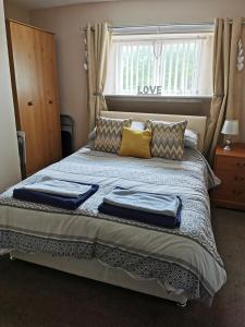 1 dormitorio con cama con almohadas y ventana en Kings Head en Berwick-Upon-Tweed