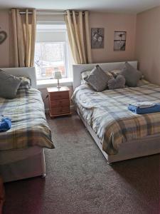 1 dormitorio con 2 camas y ventana en Kings Head en Berwick-Upon-Tweed