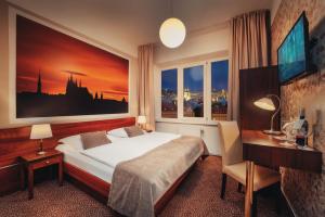 Metropolitan Old Town Hotel - Czech Leading Hotels في براغ: غرفة نوم بسرير ومكتب ونافذة