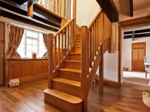 a wooden staircase in a living room with a window at Littlebeck Warren in Whitehaven