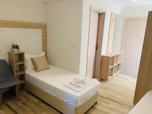 a small bedroom with a bed and a chair at Melia Mar in Sozopol