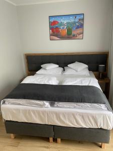 1 dormitorio con 1 cama grande con sábanas y almohadas blancas en Villa Aura, en Świnoujście