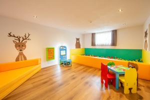 uma sala para crianças com uma mesa e uma máquina de brinquedos em Residence Alpina em Santa Maddalena in Casies