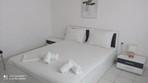 a white bed with two rolled towels on it at Elea House in Keramoti