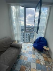 a living room with a couch and a large window at АПАРТАМЕНТЫ ВОЗЛЕ МОРЯ (КРАСИВЫЙ ЗАКАТ). in Odesa