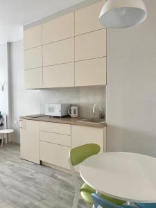 a kitchen with a white table and a table and a table and chairs at АПАРТАМЕНТЫ ВОЗЛЕ МОРЯ (КРАСИВЫЙ ЗАКАТ). in Odesa