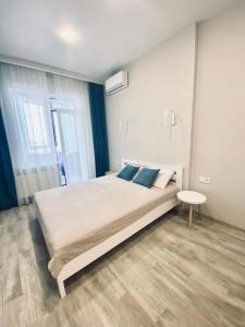 a bedroom with a large bed and a table at АПАРТАМЕНТЫ ВОЗЛЕ МОРЯ (КРАСИВЫЙ ЗАКАТ). in Odesa