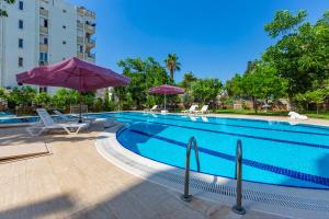 a large swimming pool with umbrellas and chairs at Melissas Suites Lara in Antalya