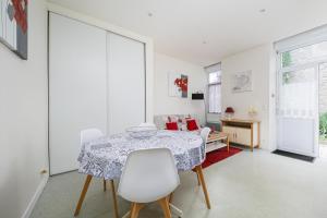 un comedor blanco con mesa y sillas en Résidence du Prieuré, en Dinard