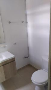 Baño blanco con aseo y lavamanos en Excelente apartamento en villeta cundinamarca, en Villeta