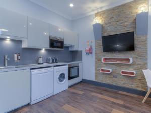 cocina con electrodomésticos blancos y pared de ladrillo en Remaotel The Bromley Apartments, en Great Yarmouth