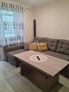un soggiorno con divano e tavolo in legno di ЗАРА a Ruse