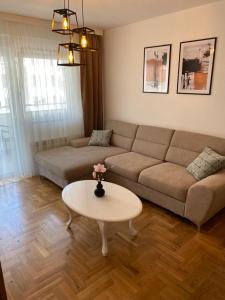 ein Wohnzimmer mit einem Sofa und einem Tisch in der Unterkunft La Perla in Trebinje