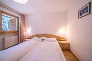 Un dormitorio con una cama grande y una ventana en Ferienhaus Maria Arnika en Pfelders