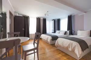 塔古玖Casa Ris的一间卧室，有两张床、一张桌子和一张书桌