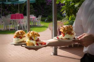 a person holding two plates of food on a table at Gasthof Bathmann in Loxstedt