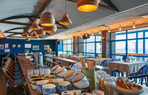 a restaurant with a long table with plates of food at Prima Tel Aviv Hotel in Tel Aviv