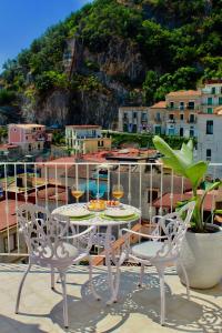 mesa y sillas en la parte superior de un balcón en Cetara Costa d'Amalfi Residence, en Cetara