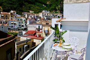 a balcony with a table and chairs and a city at Cetara Costa d'Amalfi Residence in Cetara