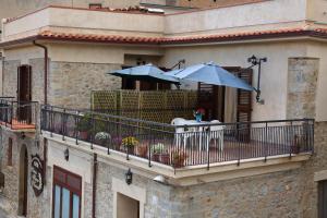 a balcony with chairs and umbrellas on a building at Antica Dimora Marinelli in Ficarra