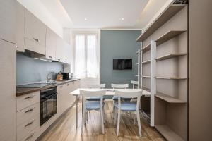 eine Küche mit weißen Schränken sowie einem Tisch und Stühlen in der Unterkunft Classbnb - luxury apartment in Monte Carlo in Beausoleil