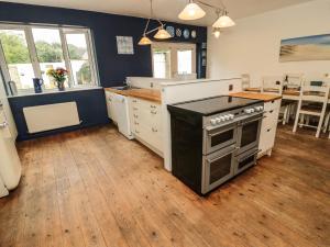 a kitchen with a stove top oven in a room at Asta Cottage in Morpeth