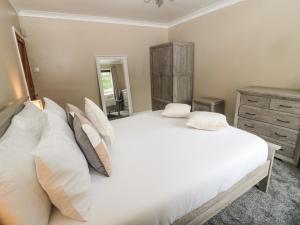 a bedroom with a large white bed with pillows at Asta Cottage in Morpeth