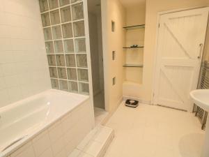 a white bathroom with a tub and a sink at Asta Cottage in Morpeth +24 photos
