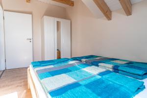 1 dormitorio con 1 cama con edredón azul en Ferienwohnung Bad Camberg - Apartment Goldener Grund, en Bad Camberg