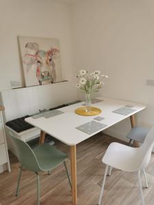 a dining room table with chairs and a vase of flowers at The Loft in Crossmolina