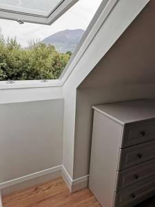 a skylight in a room with a dresser and a window at The Loft in Crossmolina