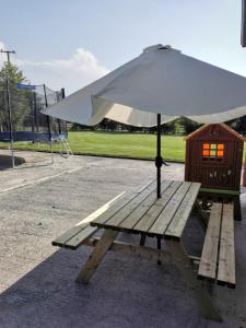 a wooden picnic table with an umbrella on it at The Loft in Crossmolina
