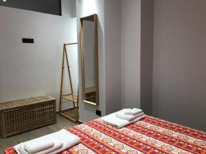 a bedroom with a bed with a mirror and towels at Dimore Albrunè in Catania