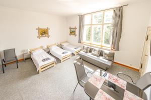 a room with two beds and a table and chairs at Stara Piekarnia - Pułaskiego 3 in Olsztyn