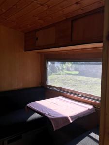 a small room with a window in a train at Camping Zamolxe in Sarmizegetusa