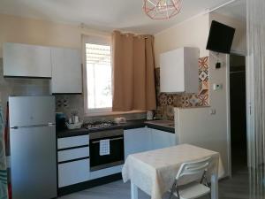 a kitchen with white appliances and a table and a window at IL RIFUGIO in VALLE D'ITRIA in Locorotondo +24 photos