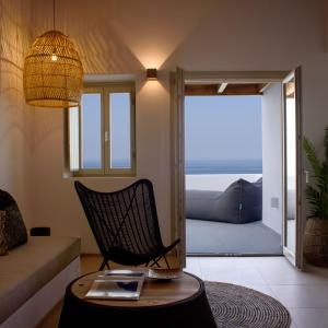 a living room with a couch and a chair and a table at Este Luxury Suites in Fira