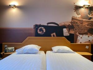 
a bed with two pillows and two nightstands at Liberty in Blankenberge
