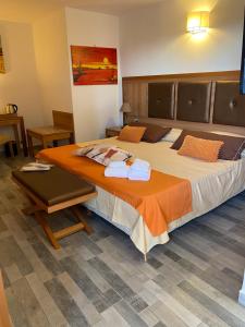 um quarto com uma cama grande e um cobertor laranja em B&B Torre Pozzillo em Cinisi