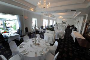 a dining room with white tables and white chairs at Bay View Hotel in Killybegs +39 photos